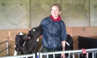 Our PhD student stands in single pen with 4 week old calf